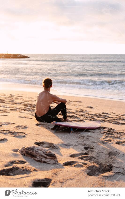 Anonymer Surfer mit Surfbrett, der sich am Meer ausruht Mann Strand Sonnenuntergang Urlaub sich[Akk] entspannen Sommer Meereslandschaft MEER männlich genießen