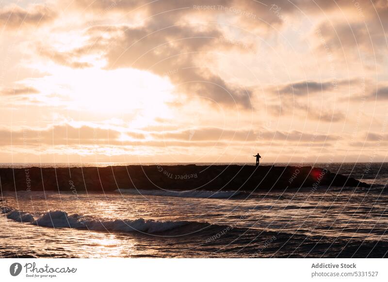 Silhouette einer Person, die bei Sonnenuntergang auf den Wellen surft MEER winken Surfen stürmisch schäumen Surfer Unwetter Wasser platschen Meereslandschaft