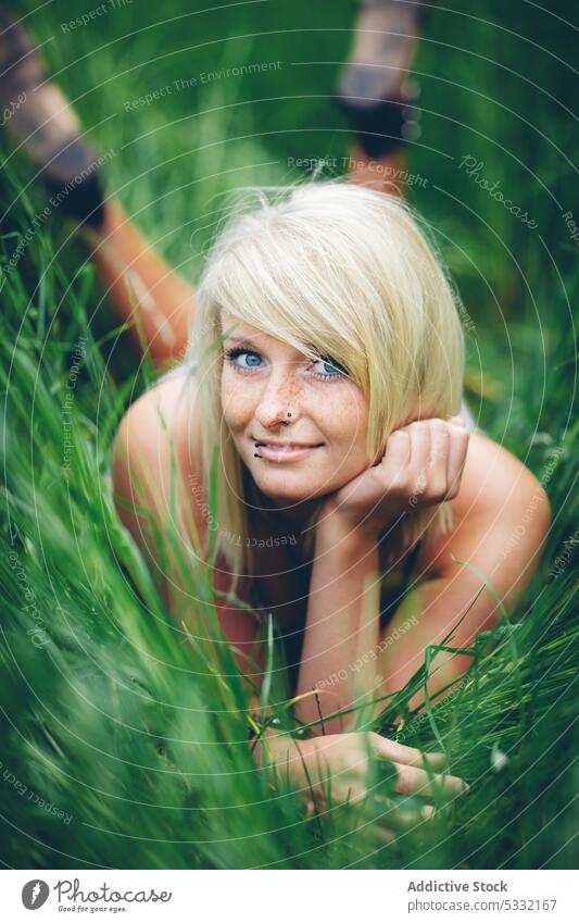 Fröhliche Frau im Feld liegend Gras jung Lächeln grün Sommer Natur niedlich Glück Freude schön Freiheit freundlich Lügen Lifestyle Freizeit ruhen blond