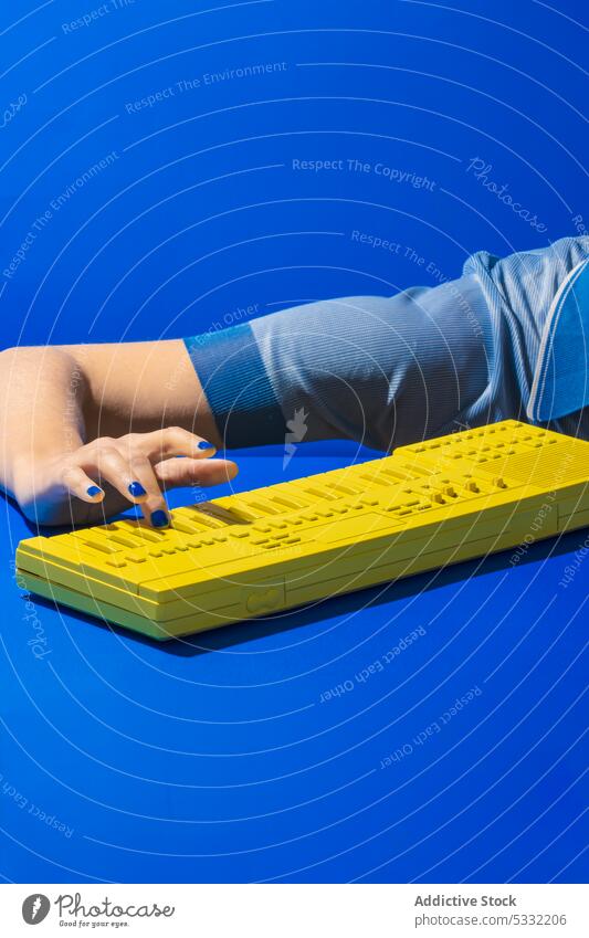 Crop-Frau spielt gelbe Synthesizertastatur Hand Keyboard spielen Klavier Musik Melodie Instrument Klang elektronisch Taste Musiker Kunst unterhalten modern