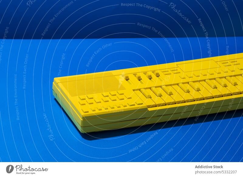Gelbe Synthesizertastatur auf blauem Hintergrund Keyboard Taste Schaltfläche gelb Klavier Instrument Musik modern elektronisch Gerät hell Kunst neu Kunststoff