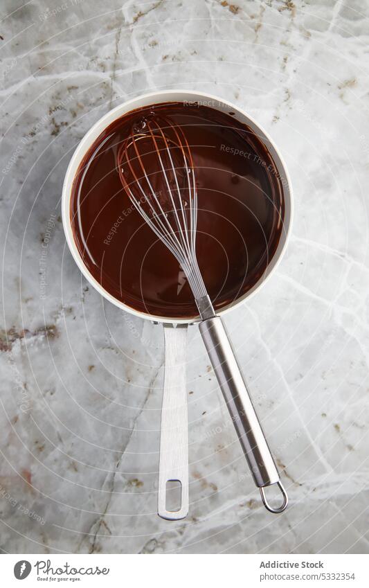 Schokolade im Kochtopf mit dem Schneebesen schmelzen zerlaufen melken Ganache süß Dessert mischen Bestandteil Prozess Küche Murmel Abfertigungsschalter