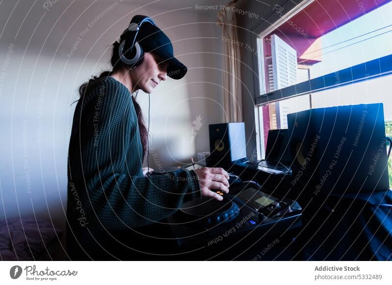 Weiblicher DJ mit Mischpult zu Hause Frau dj Konsole zuhören heimwärts Musik Atelier Regler Gerät Schaltfläche Erwachsener professionell Audio Kopfhörer