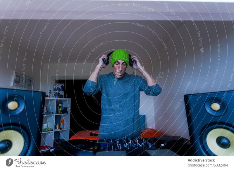Männlicher DJ mischt Musik zu Hause Mann dj Fokus Konsole Mixer Klang zuhören Gerät Kopfhörer heimwärts Audio Regler Schaltfläche unterhalten Aufzeichnen