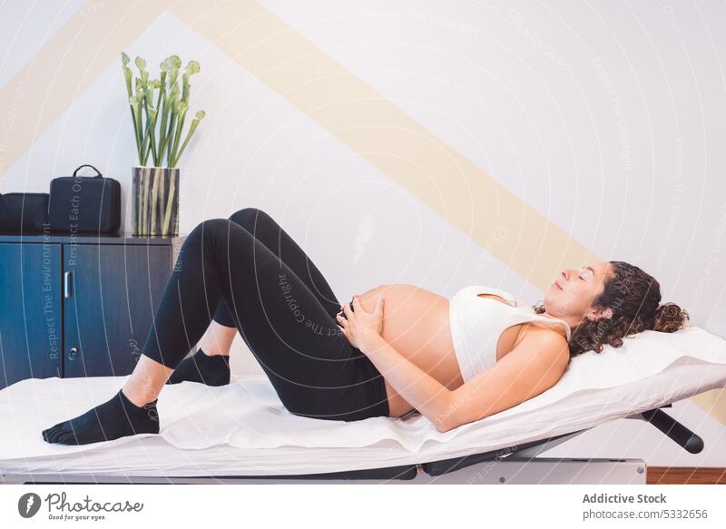 Schwangere Patientin auf dem Massagetisch in der Klinik liegend Frau schwanger sich[Akk] entspannen Osteopathie ruhen Bett Lügen erwarten Schwangerschaft Bauch