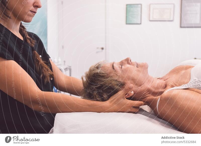 Crop-Masseurin bei der Nackenmassage eines Kunden Frau Massage geduldig Hals Verfahren Therapie Therapeut Physiotherapeutin Osteopath Lügen Rehabilitation