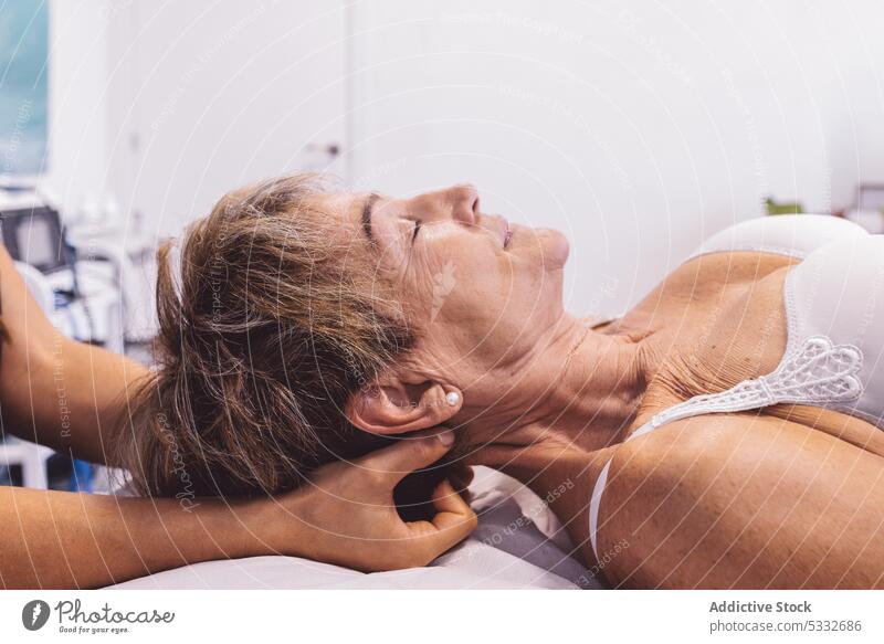 Crop-Masseurin bei der Nackenmassage eines Kunden Frau Massage Physiotherapeutin Osteopath geduldig Hals Verfahren Therapie Therapeut Lügen Rehabilitation