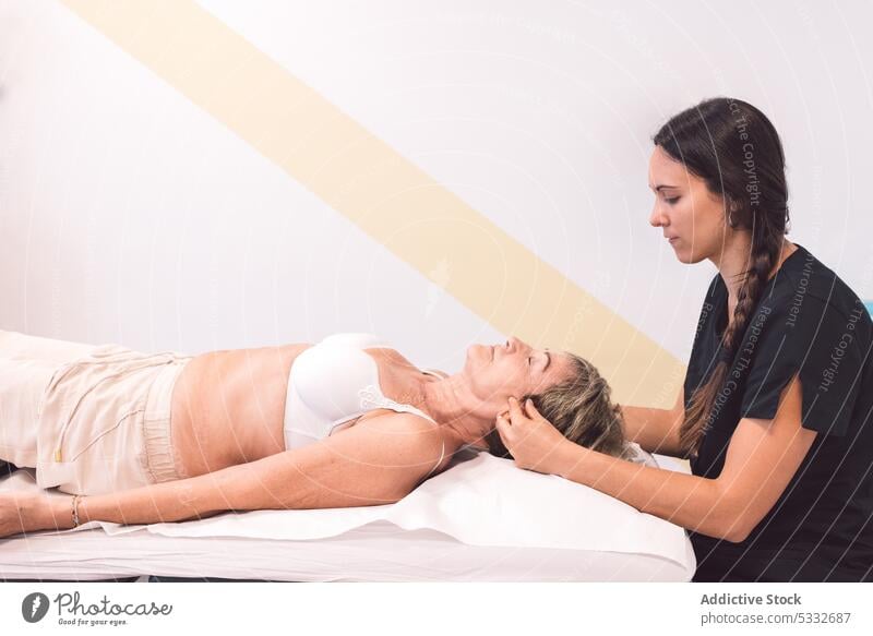Masseurin bei der Nackenmassage eines Kunden Frau Massage geduldig Hals Verfahren Therapie Therapeut Physiotherapeutin Osteopath Lügen Rehabilitation