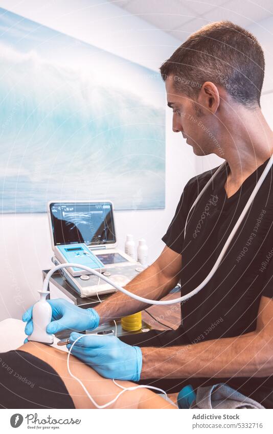 Konzentrierter Arzt bei der Ultraschalluntersuchung eines Patienten Mann geduldig untersuchen Klinik modern Ernennung Gerät Leckerbissen Physiotherapie Medizin