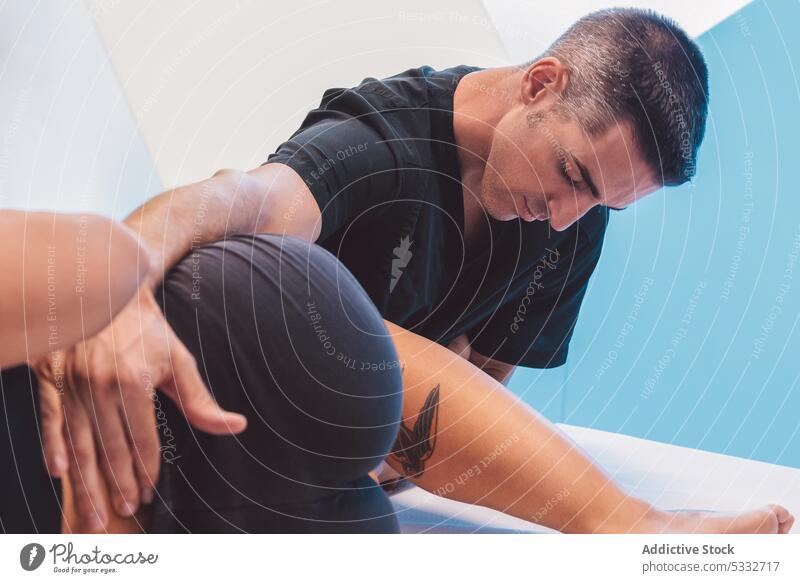 Professioneller Osteopath massiert das Bein eines Kunden in der Klinik Mann Frau Massage Osteopathie Physiotherapie geduldig Masseur Sitzung Therapeut