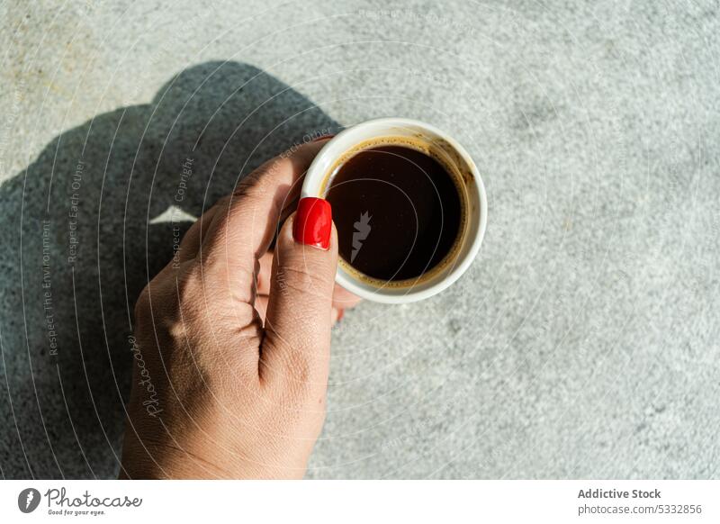 Anonyme Frau mit einer Tasse Kaffee in der Hand Getränk schwarzer Kaffee Frühstück Keramik tagsüber tiefer Schatten trinken essen Essen Espresso Lebensmittel