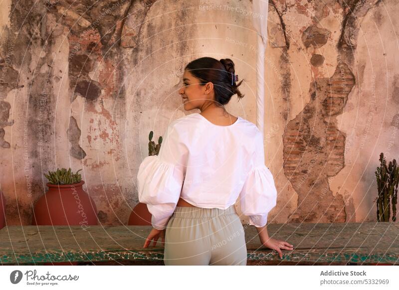 Rückenansicht einer stilvoll gekleideten Frau, die in der Nähe eines Tisches an einem alten Gebäude steht Stil Lächeln Topf Kathedrale natürlich besuchen