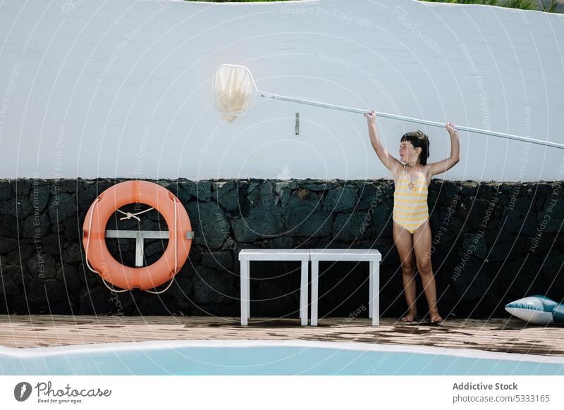 Kleines Kind benutzt Pool-Skimmer-Netz Mädchen Sauberkeit Wasser Oberfläche Urlaub Barfuß Kindheit Hof Sommer Beckenrand Feiertag Resort übersichtlich Aktivität