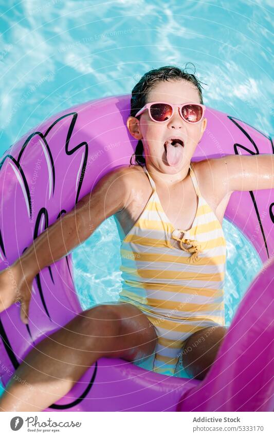 Kleines Kind ruht sich im Schwimmbad aus Mädchen Pool schwimmen Wasser rausstrecken Zunge sich[Akk] entspannen ruhen Schwimmer aufblasbar Sommer Feiertag Ring
