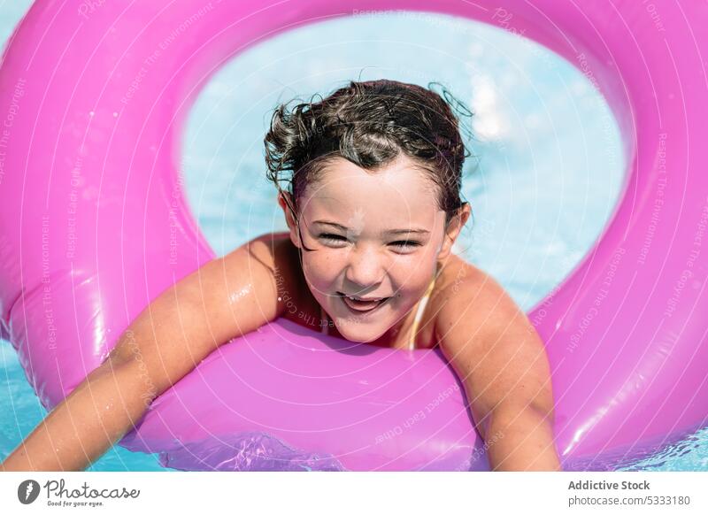 Fröhliches Mädchen schwimmt im Pool Kind Wasser schwimmen genießen Lächeln ruhen Freude heiter aufblasbar Glück Urlaub Tube Sommer Feiertag Ring Kindheit Resort