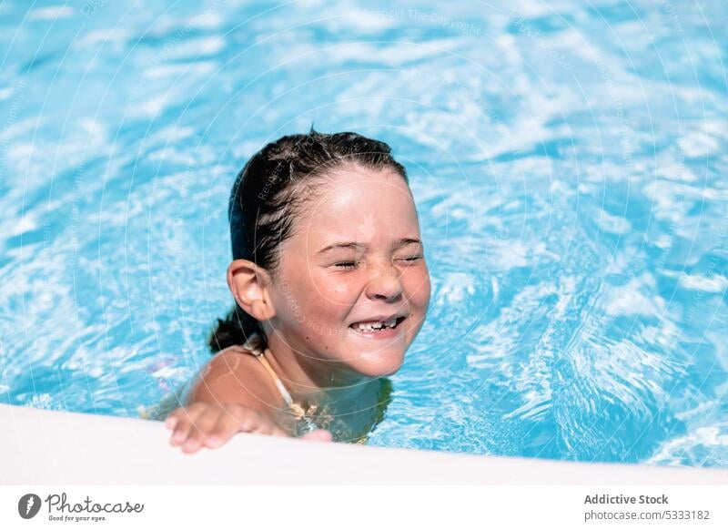 Glückliches Kind mit geschlossenen Augen beim Schwimmen im Pool Mädchen Lächeln schwimmen genießen Feiertag heiter Sommer Urlaub sich[Akk] entspannen Freude