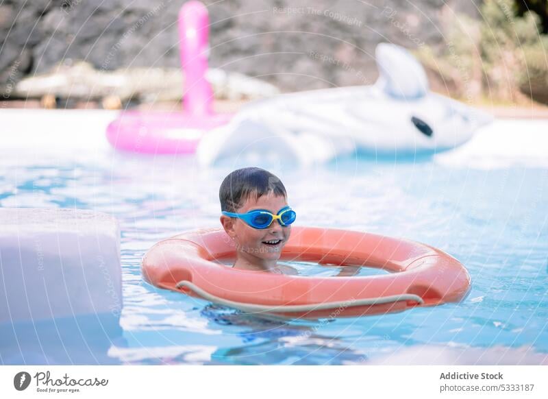 Kleines Kind schwimmt unter Wasser im Pool Junge Schwimmer schwimmen heiter aufblasbar Urlaub Lächeln Glück Kindheit Sommer Tube Feiertag Ring Resort