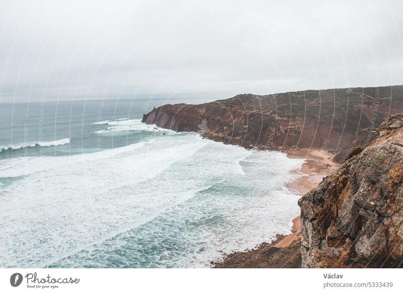 Stürmisches Wetter über den felsigen Klippen der südwestportugiesischen Algarve-Region. Die Kraft des Ozeans. Wanderung auf dem Fischerpfad, Rota Vicentina