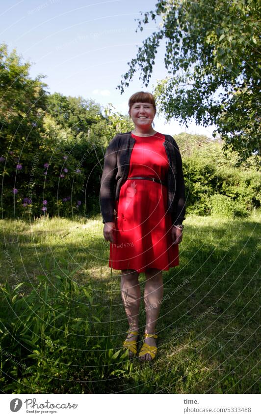 Gartenstolz Frau Portrait weiblich feminin lachen zufrieden glücklich Wiese sonnig Baum Kleid Jacke rot Sommer warm stehen fröhlich natürlich selbstbewußt