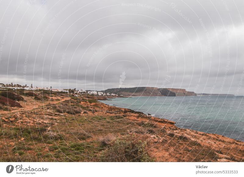Gebirgsküste der südlichen Halbinsel Portugals in der berühmten Touristenregion Algarve. Die felsigen Klippen um die Stadt Luz. Entdeckungsreise auf dem Fischerpfad, Rota Vicentina