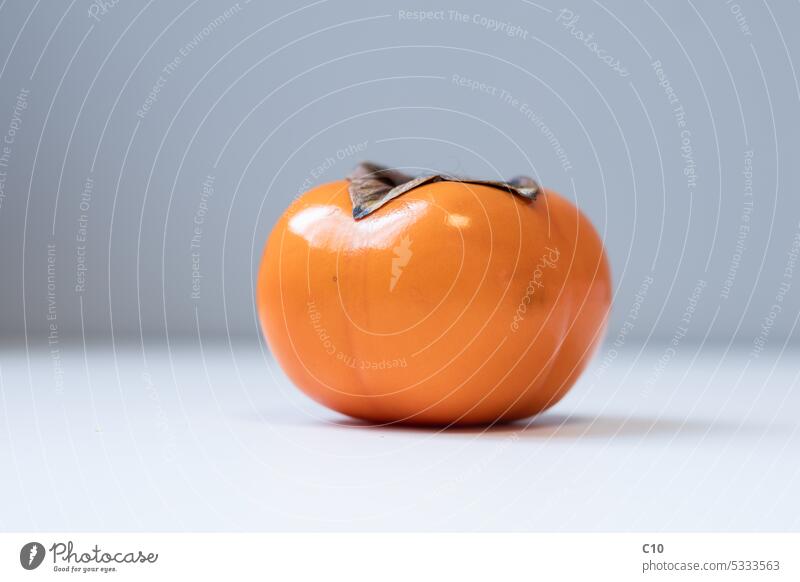 Nahaufnahme einer Kakifrucht. Studioaufnahme chinesische Kultur fuyu Gesunde Ernährung Japan Japanische Kultur orange Farbe Persimone Dattelpflaumenbaum