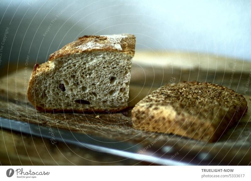 Zwei Stücke Brot mit langem Messer auf Holzbrett, Brote frisches Brot Bio-Brot Vollkornbrot Ciabatta italienisch französisch Landbrot Dinkelbrot Weizenbrot