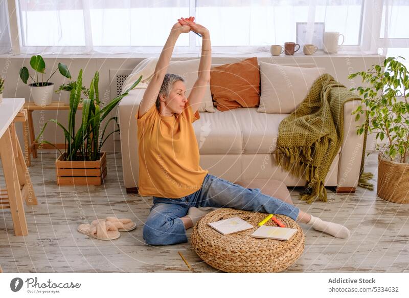 Erwachsene Frau meditiert und genießt das Leben nach überstandenem Krebs Yoga meditieren üben Wiederherstellung Rehabilitation Dehnung Sofa heimwärts