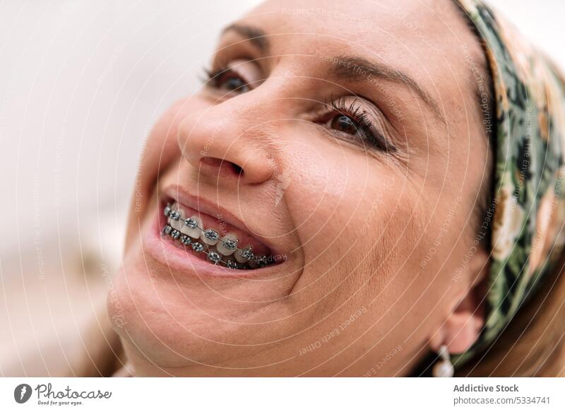 Lächelnde Patientin mit Kopftuch und Zahnspange Frau Klammer dental Verfahren Leckerbissen geduldig Glück Zähne positiv Optimist heiter Klinik mündlich froh