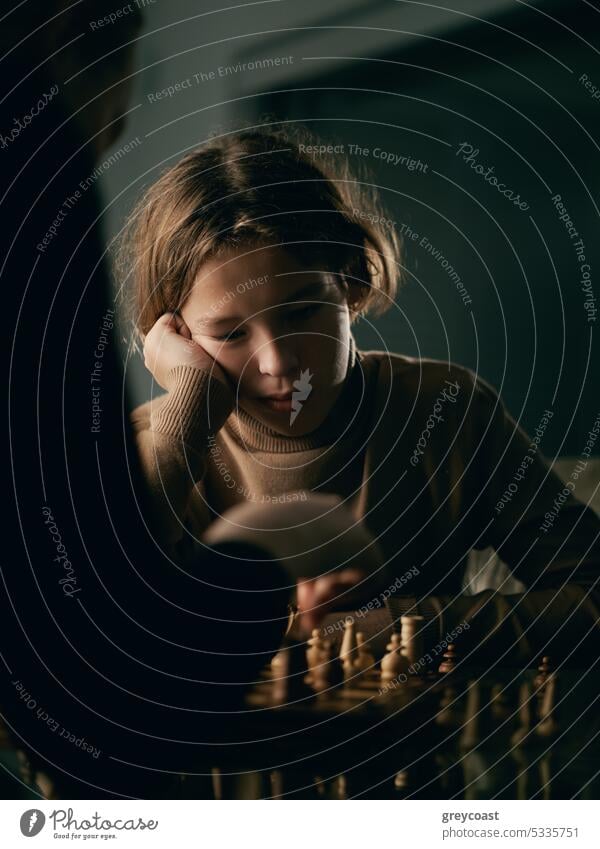 Teenager 12 Jahre alt spielt Schach Junge Kinder Holzplatte Spiel Spielen Sohn Strategie Konkurrenz Bildung Intelligenz Schatten Denken männlich Menschen