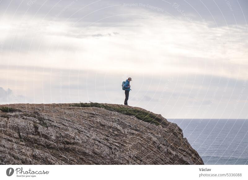 Der Reiseliebhaber genießt seine Freiheit in der portugiesischen Landschaft an der Atlantikküste und beobachtet das endlose Meer und die Formen der Klippen. Wandern auf dem Fischerpfad