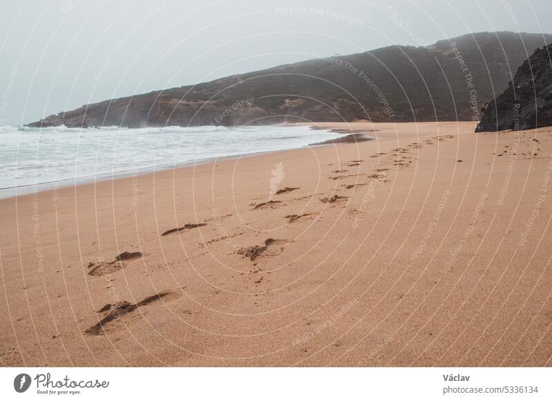 Wanderung entlang des Fisherman Trail in der Algarve-Region im Südwesten Portugals. Menschliche Fußabdrücke in der sandigen Oberfläche Fußspur Sand Schritt