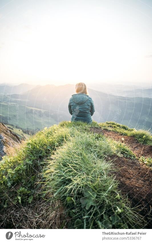 Frau sitzt auf Felsvorsprung und schaut in den Sonnenuntergang Schweiz appenzellerland Außenaufnahme Tourismus Berge u. Gebirge Farbfoto Alpstein Natur Gras