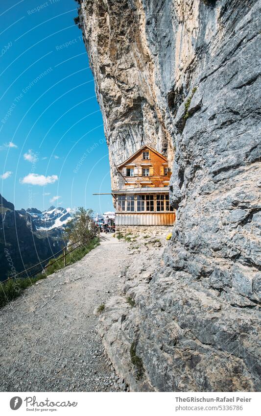 Haus im Fels gebaut mit Fels im Vordergrund und blauem Himmel Felsen Schweiz Appenzellerland äscher Stein wandern beliebt touristisch Außenaufnahme Tourismus