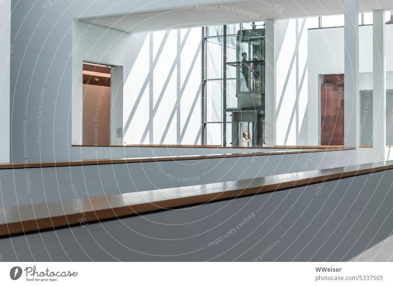 Ein interessant gestalteter moderner Raum, Galerie mit Aufzug, Licht und Schatten Innenaufnahme Halle Treppe kühl Linien Geländer Türen verschachtelt Museum