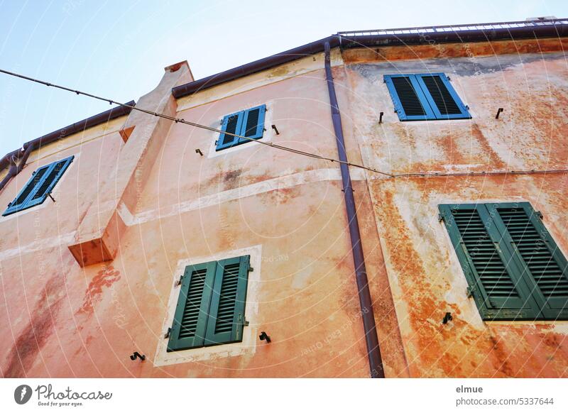 wohnen auf Elba - verwinkeltes helles Wohngebäude mit Fensterläden vor den Fenstern aus der Froschperspektive Wohnhaus Poggio Italien Insel Blog Mittelmeer