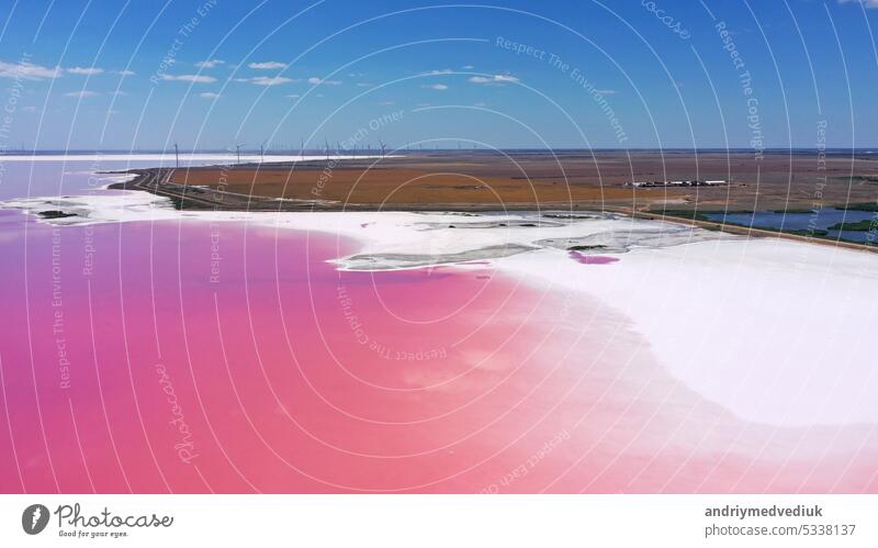 Luftaufnahme von White Salz an den Ufern der Insel in Pink Island und blauer Himmel . Lemuria-See, Ukraine. See wird natürlich rosa aufgrund von Salzen und kleinen Krebstieren Artemia im Wasser