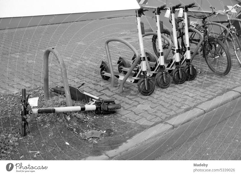 Umgestürzter E-Scooter für Touristen auf dem Verbundpflaster eines Bürgersteig in der Friedberger Landstraße im Nordend von Frankfurt am Main in Hessen in neorealistischem Schwarzweiß