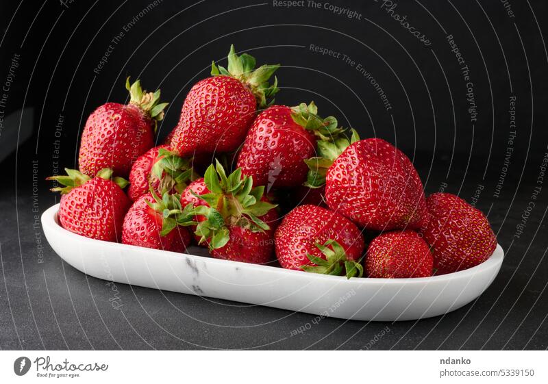 Reife rote Erdbeeren auf einem schwarzen Tisch Menschengruppe ganz reif Beeren Frucht Lebensmittel frisch Diät saftig Frische süß roh Ernte niemand