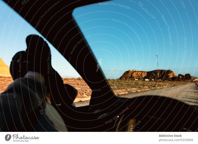 Unerkennbare Füße eines Touristen im Auto bei der Besichtigung der Wüste PKW Fuß ruhen Reisender Straße Ausflug sich[Akk] entspannen reisen Fenster Autoreise