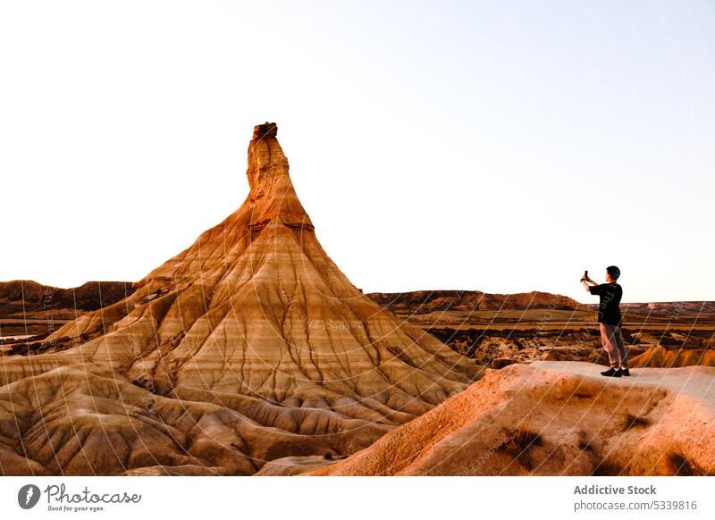 Reisende, die eine Felsformation in der Wüste fotografieren Mann Reisender Tourist erkunden Natur Felsen reisen Landschaft wüst Smartphone männlich Saum