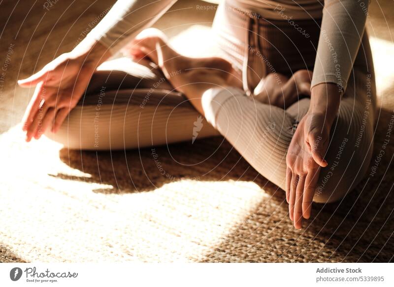 Crop weiblich meditiert auf Teppich mit Lotus-Pose Yoga meditieren Frau üben Zen Gesundheit padmasana Wellness Barfuß Stressabbau Windstille Harmonie ruhig