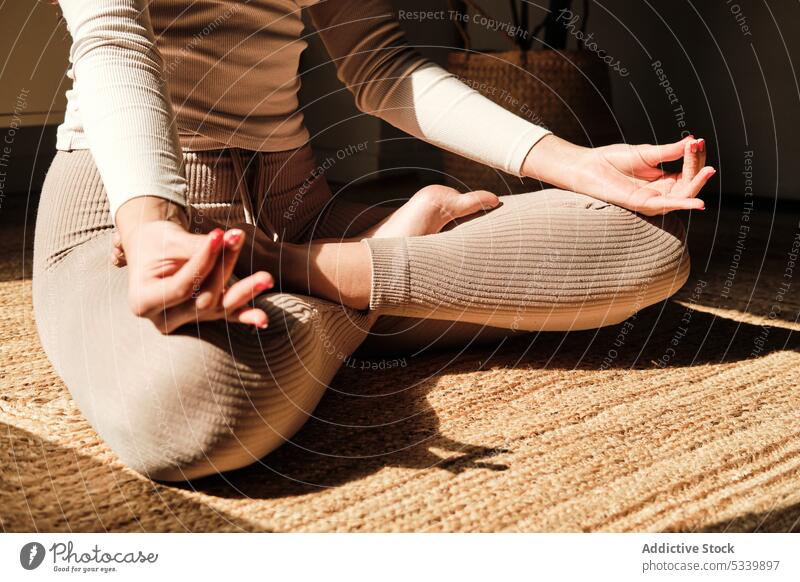 Crop weiblich meditiert auf Teppich mit Lotus-Pose Yoga meditieren Frau üben Zen Gesundheit padmasana Wellness Barfuß Stressabbau Windstille Harmonie ruhig