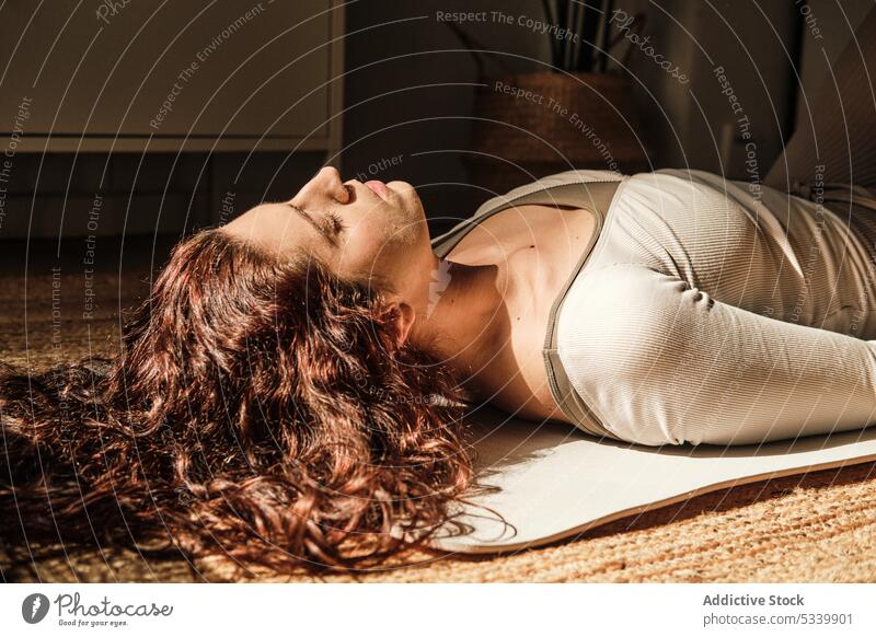 Unbekannte Frau in Shavasana-Pose zu Hause Leichenpose Yoga üben Asana Zen shavasana Achtsamkeit Gleichgewicht meditieren Stressabbau Augen geschlossen Dehnung