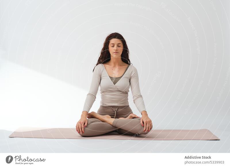 Meditierende Frau mit Lotussitz und Namaste-Händen Yoga padmasana meditieren üben Barfuß Achtsamkeit Wellness Konzentration Lotus-Pose Atelier Zen Gesundheit
