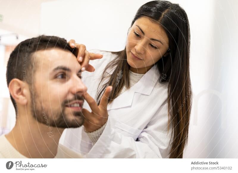 Augenarzt setzt Linse in das Auge eines männlichen Patienten ein Ophthalmologe Mann geduldig Lächeln Leckerbissen Klinik Spezialist bewerben setzen Glück