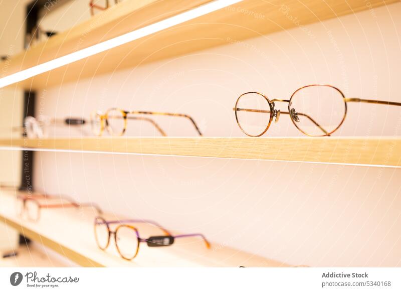 Brillen auf beleuchteten Regalen im Geschäft Laden optisch Stil Zeitgenosse Design modern Sammlung leuchten Licht Rahmen Einzelhandel Innenbereich Werkstatt