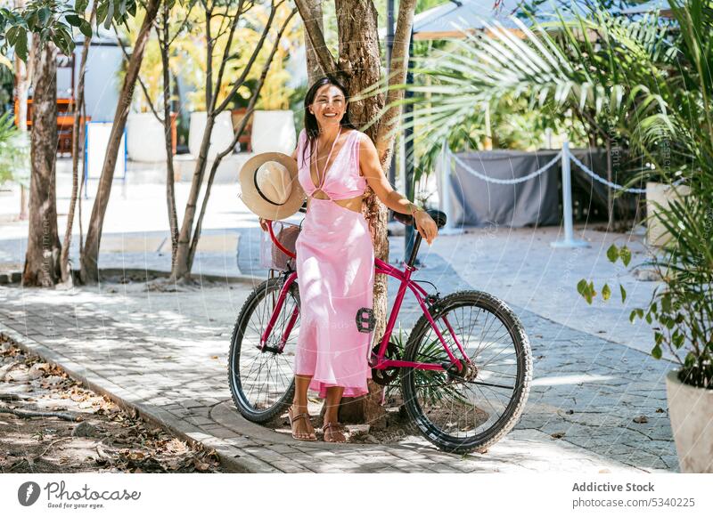 Fröhliche Frau mit Fahrrad auf der Straße Sommer positiv Großstadt Stil Glück Lächeln jung Tulum Mexiko mexikanisch asiatisch Japanisch Kleid gemischte Rasse