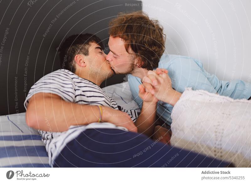 Schwules Paar küsst sich auf dem Bett Männer kuscheln sich[Akk] entspannen Wochenende Zusammensein heimwärts Küssen Lippen Glück Liebe ruhen schwul Lügen jung