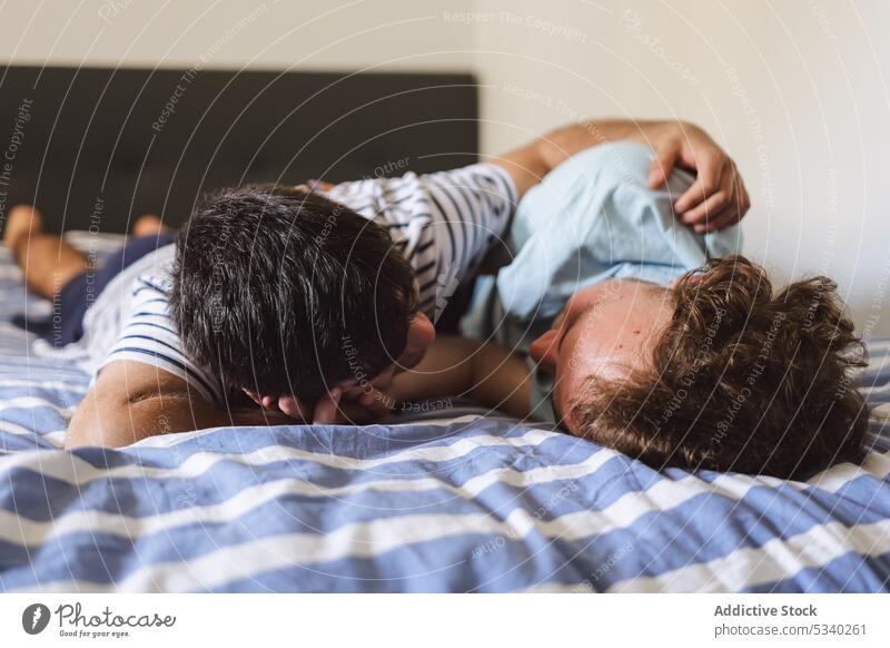 Liebendes homosexuelles Paar, das sich auf dem Bett küsst und umarmt schwul kuscheln Kuss Zusammensein Umarmung Partnerschaft heimwärts Zuneigung Umarmen