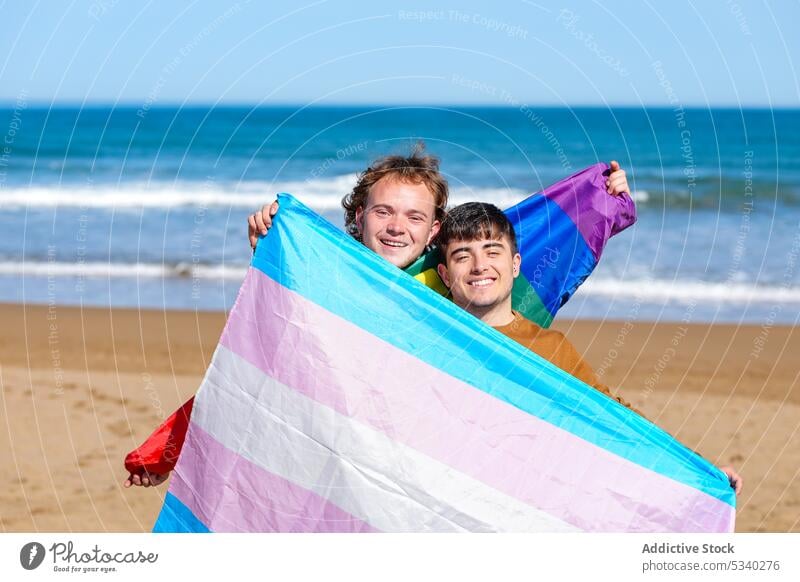 Zufriedenes schwules Paar ruht sich am Sandstrand aus Männer Partner lgbt Fahne Feiertag feiern Strand MEER männlich lgbtq Homosexualität transsexuell